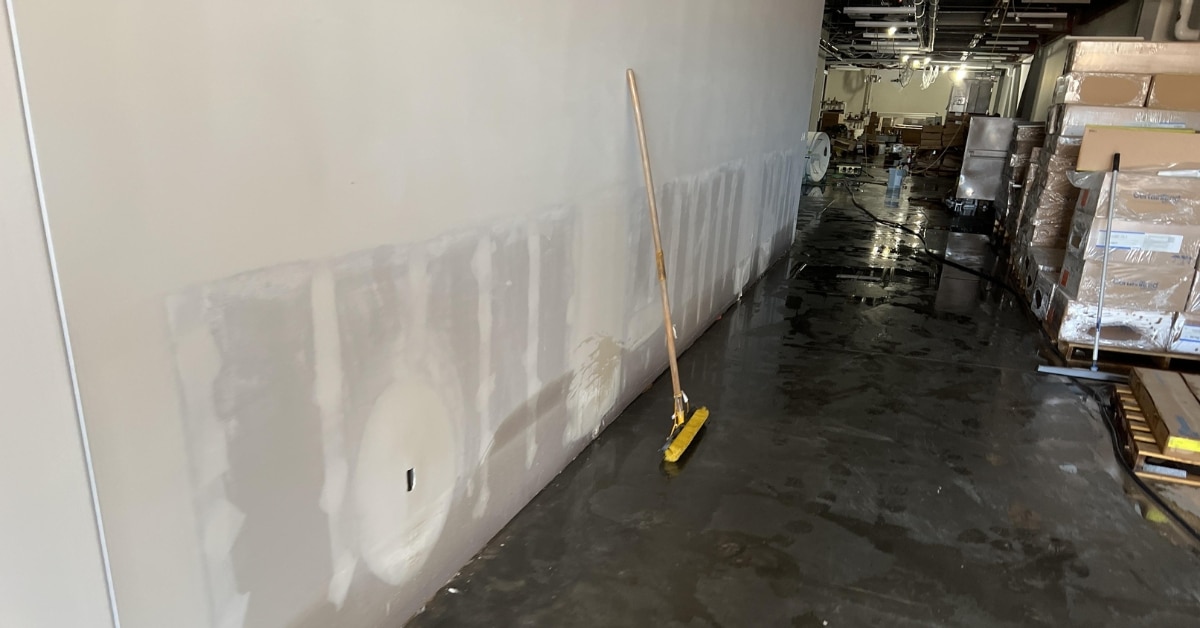 Technician extracting water from a flooded commercial building