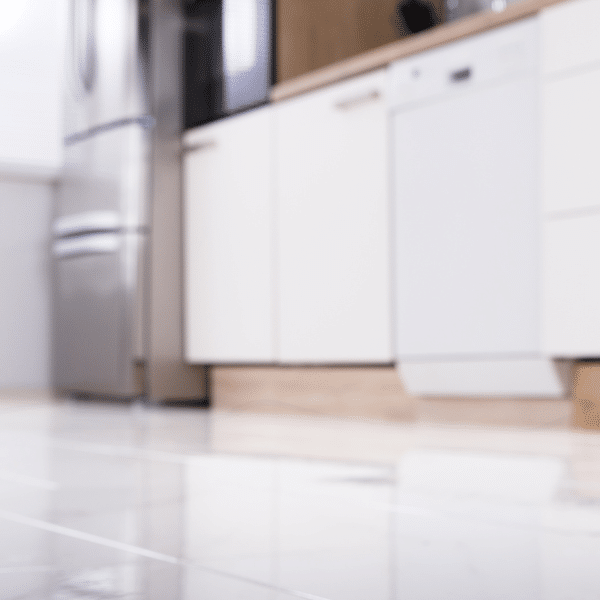 Homeowner checking under dishwasher for water leak